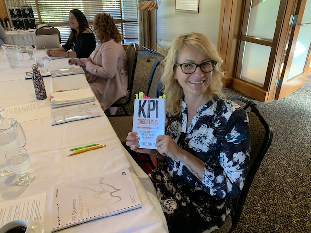 Corporate student holding a copy of KPI Checklists